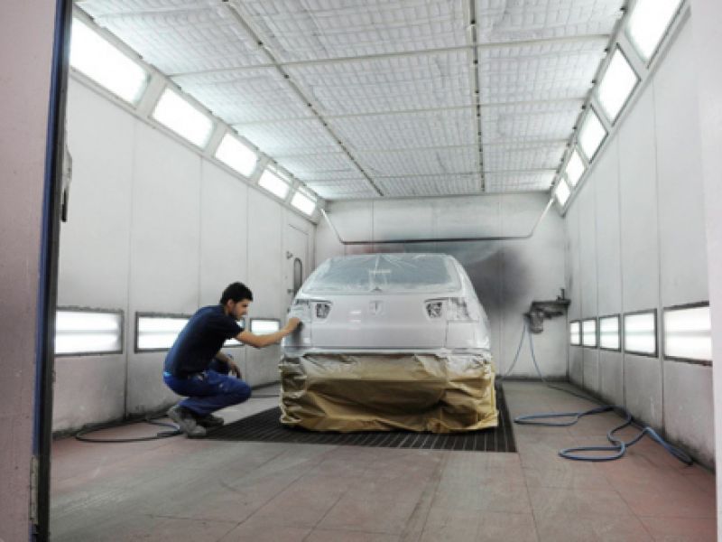 Mecánico en interior de cabina de pintura