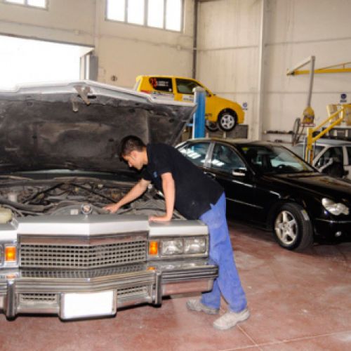 Coche en reparación con mecánico en primer plano